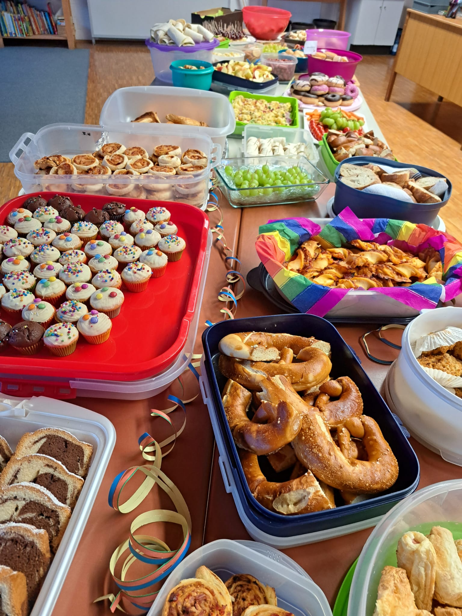 Viele Leckereien wie Muffins, Brezeln und andere Süßigkeiten auf einem langen Tisch